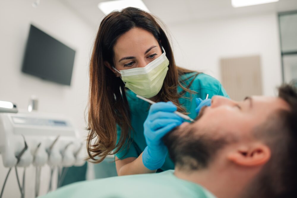 Dentist examining patient’s teeth during a routine dental checkup in McKinney, TX